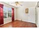 Bedroom with hardwood floors, red curtains, a ceiling fan, and a window overlooking a wooded area at 3709 Mcguire Nw St, Kennesaw, GA 30144