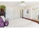 Spacious bedroom with cream-colored walls, showing door and dresser, ceiling fan, and a view to adjacent room at 3709 Mcguire Nw St, Kennesaw, GA 30144