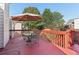 Back deck with an umbrella, table and chairs on a red painted deck at 3709 Mcguire Nw St, Kennesaw, GA 30144