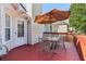 Outdoor deck space with table, chairs, umbrella, and red flooring at 3709 Mcguire Nw St, Kennesaw, GA 30144