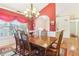 Formal dining room with a wooden table and chairs, chandelier, and large window at 3709 Mcguire Nw St, Kennesaw, GA 30144