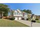 Two-story home featuring a two-car garage, well-maintained lawn and manicured bushes, and a brick facade at 3709 Mcguire Nw St, Kennesaw, GA 30144