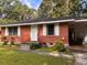 A quaint red brick home with a clean lawn and a carport on the right at 4513 College St, Forest Park, GA 30297