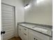 Bathroom vanity featuring double sinks, granite countertops, and sleek white cabinetry at 6149 Pinewood Se Dr, Covington, GA 30014