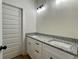 Bathroom vanity featuring double sinks, granite countertops, and sleek white cabinetry at 6149 Pinewood Se Dr, Covington, GA 30014