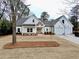 Charming white farmhouse exterior featuring a gable roof, two-car garage and beautifully landscaped front yard at 6149 Pinewood Se Dr, Covington, GA 30014