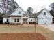 Beautiful exterior of a modern farmhouse-style home with white siding, gabled roof, and a two-car garage at 6149 Pinewood Se Dr, Covington, GA 30014