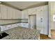 Kitchen featuring white cabinets, granite countertops, and a center island with a sink at 6149 Pinewood Se Dr, Covington, GA 30014