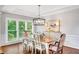 Formal dining room featuring hardwood floors, a stylish light fixture, and a view of the lush outdoor greenery at 1473 Cardova Pointe, Dunwoody, GA 30338