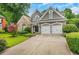 Two-story home featuring a stone facade, well-manicured lawn, and attached garage at 1473 Cardova Pointe, Dunwoody, GA 30338