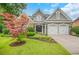 Beautiful gray home with a stone facade, a green lawn, and a two-car garage at 1473 Cardova Pointe, Dunwoody, GA 30338