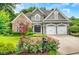 Charming home featuring a stone facade, well-manicured lawn and a two-car garage at 1473 Cardova Pointe, Dunwoody, GA 30338