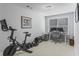 Well-equipped home gym and office area with exercise bike, weight set, desk, and natural light from the window at 2772 Archway Ln, Brookhaven, GA 30341