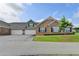 Charming brick townhome featuring a two-car garage, well-manicured lawn, and classic architectural details at 3411 Lindenridge Dr, Buford, GA 30519