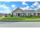 Charming brick townhome featuring a lush green lawn, tidy landscaping, and inviting curb appeal at 3411 Lindenridge Dr, Buford, GA 30519