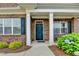 Inviting entryway showcasing a blue front door flanked by white columns and manicured landscaping at 3411 Lindenridge Dr, Buford, GA 30519