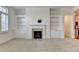 Cozy living room featuring a fireplace, built-in shelves, and natural light from the window at 3411 Lindenridge Dr, Buford, GA 30519