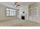 Spacious living room with a decorative fireplace, built-in shelving, and bright window at 3411 Lindenridge Dr, Buford, GA 30519