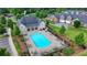 Aerial view of a community pool featuring lounge chairs, tables, manicured landscaping, and ample seating at 3411 Lindenridge Dr, Buford, GA 30519