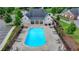 Aerial view of a community pool featuring lounge chairs, tables, manicured landscaping, and ample seating at 3411 Lindenridge Dr, Buford, GA 30519