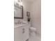 Neat bathroom with white vanity, toilet, and sink, plus a mirror and wood-style wall paneling at 607 Hickory Creek Ln, Woodstock, GA 30188