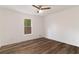 Empty bedroom featuring modern ceiling fan, wood floors and natural light from the window at 607 Hickory Creek Ln, Woodstock, GA 30188