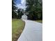 Long, newly paved driveway leading to a detached garage surrounded by green lawn and trees at 607 Hickory Creek Ln, Woodstock, GA 30188