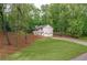 A charming home featuring a lush lawn, mature trees, and a detached garage at 607 Hickory Creek Ln, Woodstock, GA 30188