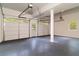 Bright garage featuring a gray floor, two garage doors with windows and a service door at 607 Hickory Creek Ln, Woodstock, GA 30188