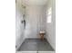 Modern shower with a glass enclosure, gray tiled floor, and a small stool at 607 Hickory Creek Ln, Woodstock, GA 30188