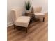 Elegant chairs are arranged around a small table on the wood-look flooring in the staged area at 607 Hickory Creek Ln, Woodstock, GA 30188