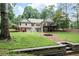 Beautiful backyard featuring a two-story home, fire pit, and lush green lawn at 1104 Fox Ln, Woodstock, GA 30188