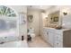 Bathroom featuring a soaking tub and a granite vanity with a decorative mirror at 1104 Fox Ln, Woodstock, GA 30188