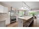 Modern kitchen with stainless steel appliances, a central island with seating, and bright natural light from the windows at 1104 Fox Ln, Woodstock, GA 30188