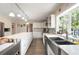 Well-lit kitchen featuring stainless appliances, custom backsplash and large sink under window at 1104 Fox Ln, Woodstock, GA 30188