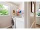 Efficient laundry room with front load machines, storage shelves, and a bright window at 1104 Fox Ln, Woodstock, GA 30188