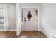 Bright foyer with decorative glass door, wood flooring, and white shiplap accent wall at 1139 Shiloh Nw Ln, Kennesaw, GA 30144
