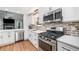 Updated kitchen featuring stainless steel appliances, white cabinetry, brick backsplash, and quartz countertops at 1139 Shiloh Nw Ln, Kennesaw, GA 30144