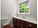 Cozy bathroom featuring a window and vanity with wood cabinets and a white countertop at 3545 Turtle Cove Se Ct, Marietta, GA 30067