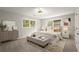 Cozy bedroom with neutral walls, carpet, dresser, bench, ceiling fan, and two windows at 3545 Turtle Cove Se Ct, Marietta, GA 30067