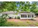 Exterior shot showing white siding and windows with view of sunroom surrounded by a lush yard at 3545 Turtle Cove Se Ct, Marietta, GA 30067
