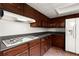 Kitchen featuring dark wood cabinets, a gas range, and white appliances at 3545 Turtle Cove Se Ct, Marietta, GA 30067
