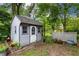 Charming shed with a white door, windows, and gray siding in a well-maintained backyard at 3545 Turtle Cove Se Ct, Marietta, GA 30067