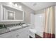 Bright bathroom featuring a vanity with granite counters, modern fixtures, and a tub with tile surround at 406 Northdale Ct, Lawrenceville, GA 30046