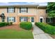 Traditional brick townhouse with dark shutters, manicured bushes, and a walkway leading to the front door at 406 Northdale Ct, Lawrenceville, GA 30046