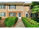 Inviting townhome featuring a brick facade, black shutters, and lush green landscaping at 406 Northdale Ct, Lawrenceville, GA 30046