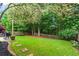 Spacious, fenced-in backyard with a gas grill and lots of trees at 585 Ashland Pkwy, Woodstock, GA 30189