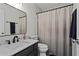 Bathroom featuring a toilet, single sink and a shower with a neutral-toned curtain at 585 Ashland Pkwy, Woodstock, GA 30189