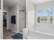 Bright bathroom featuring a soaking tub, walk-in shower and large window at 585 Ashland Pkwy, Woodstock, GA 30189