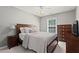 Cozy bedroom featuring a bed, bedside table, dresser, and a window at 585 Ashland Pkwy, Woodstock, GA 30189